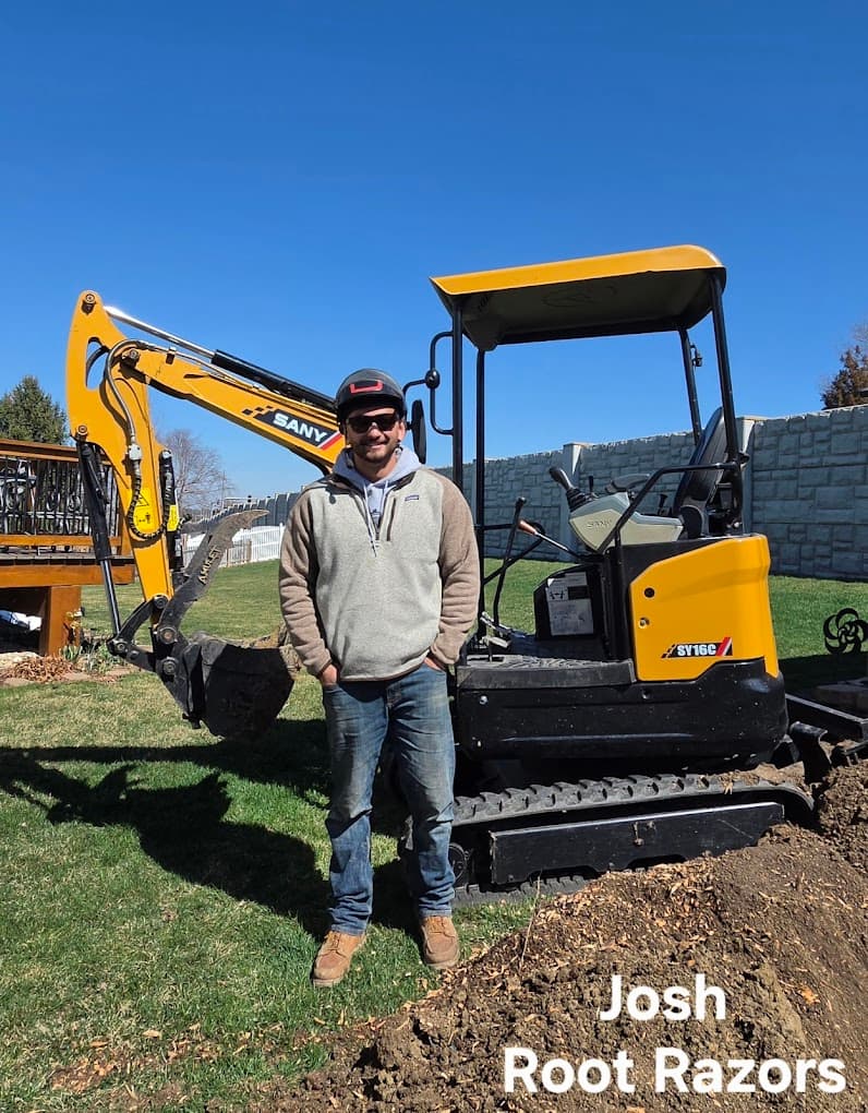 Josh, owner of Root Razors Stump Grinding LLC, standing with equipment on a job site